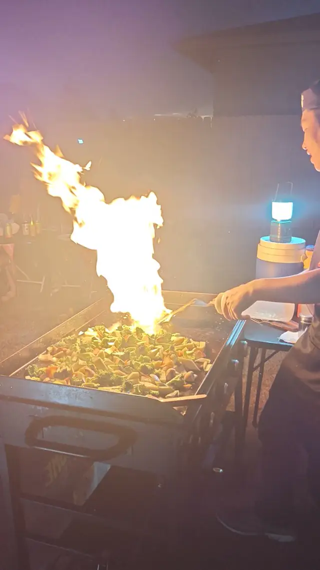 A column of flame rises off the teppan grill as the chef cooks